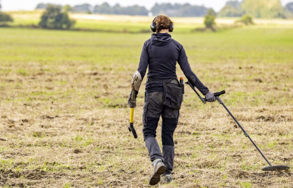 Detectorist searching af field for metal objects