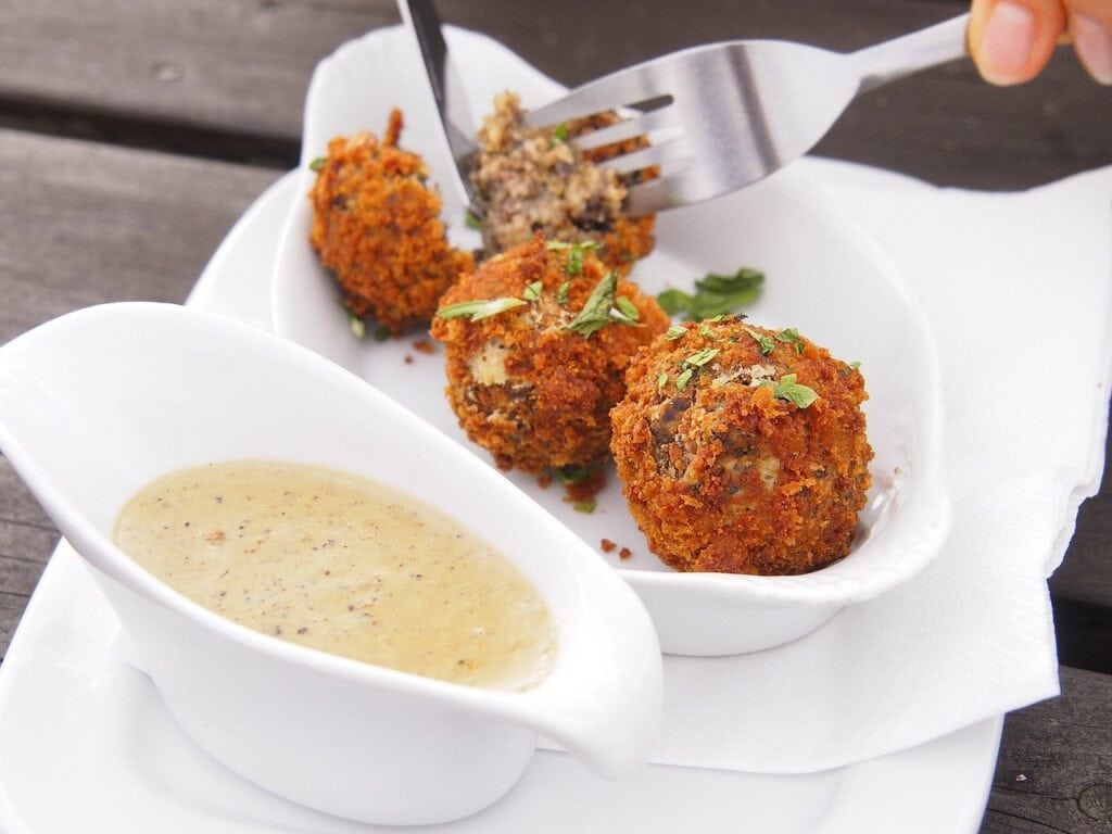 Haggis meatballs on a white plate with a meatball gravy traditional Scottish foods