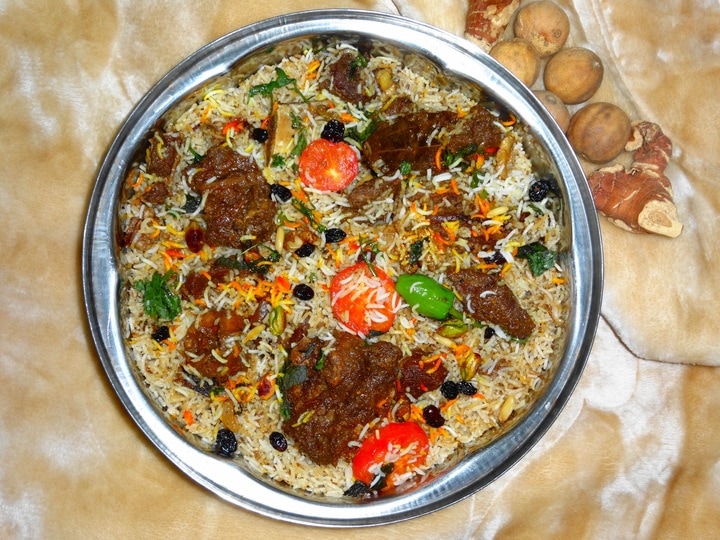 A plate of national dishes with meat and vegetables in it.