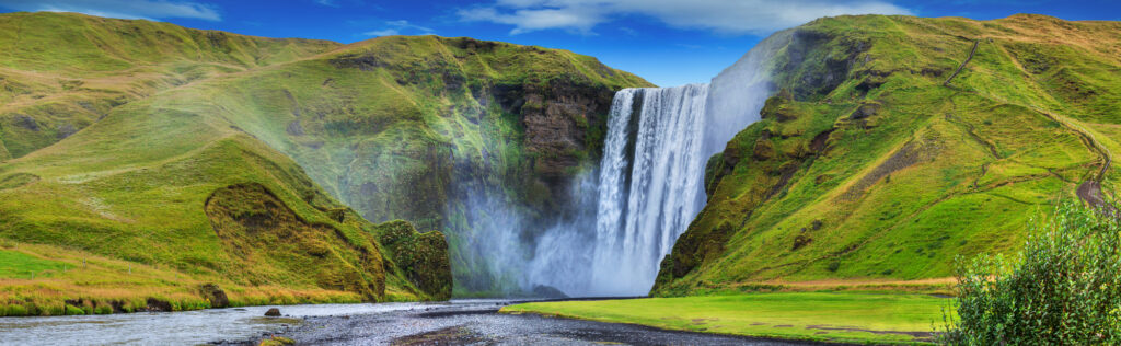 Iceland wildlife - the gorgeous waterfalls flowing over green cliffs in Iceland