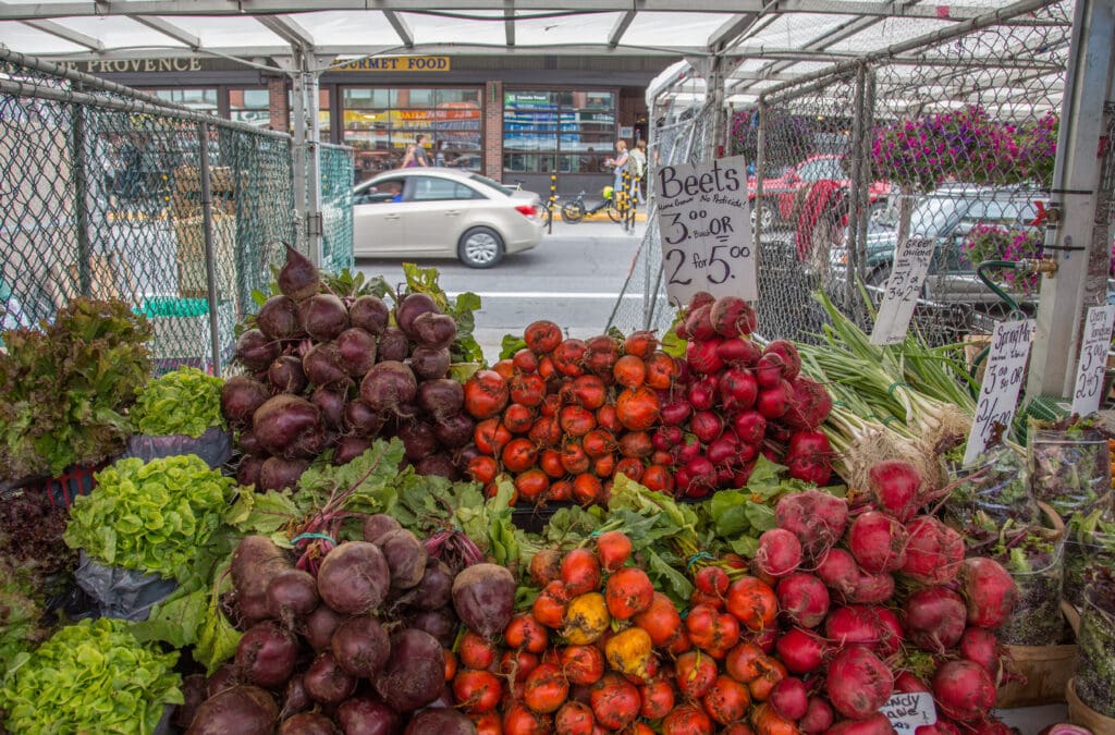 21 Best food markets Canada a view of fresh vegetables for sale, beets in all colours from orange, purple, red, yellow along with lettuces, spring onions 