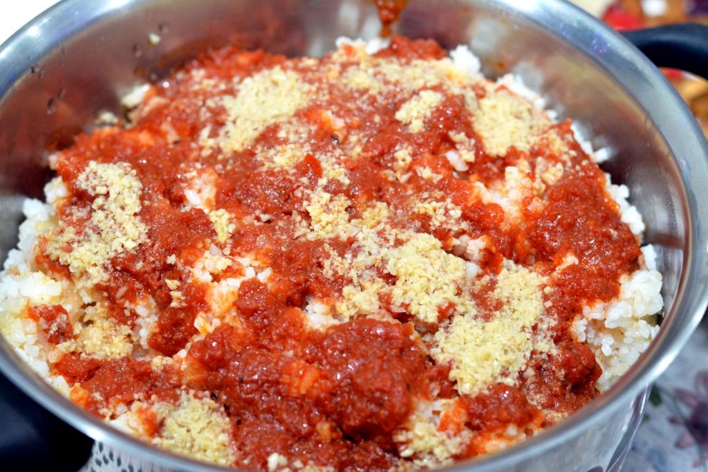 Spiced meats in a dish layered with rice and dried bread with a broth over the top to soften