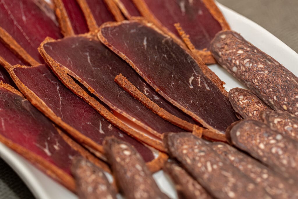 A plate of Armenian meats and sausages on a table.