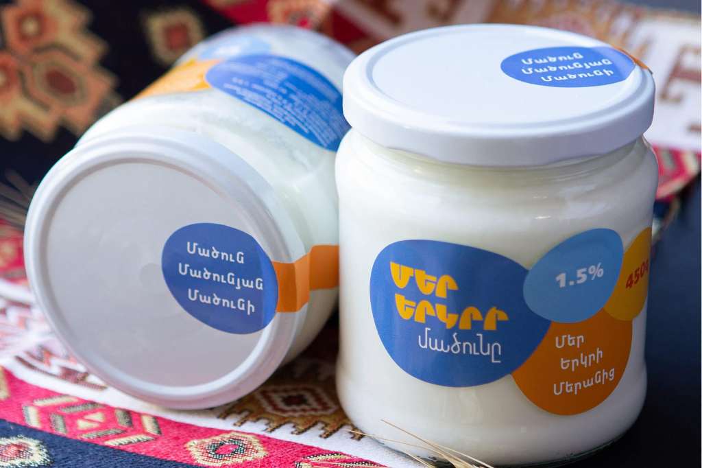 Two jars of Armenian yogurt sitting next to each other.