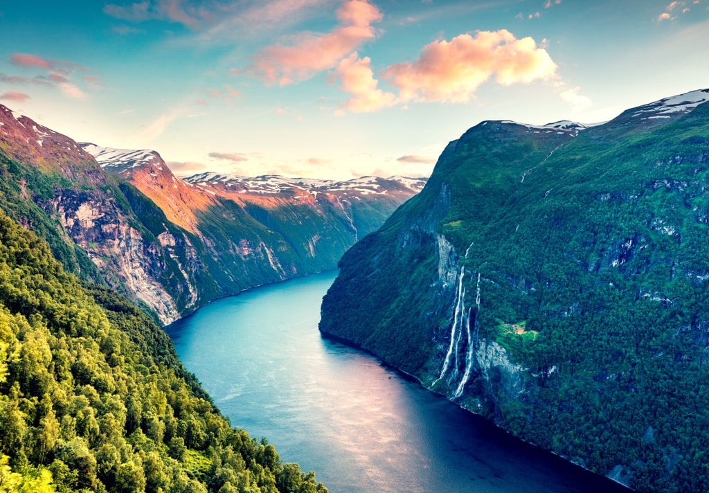 Splendid summer sunset of Sunnylvsfjorden fjord canyon, Geiranger village location, western Norway. Aerial evening view of famous Seven Sisters waterfalls. Beauty of nature concept background