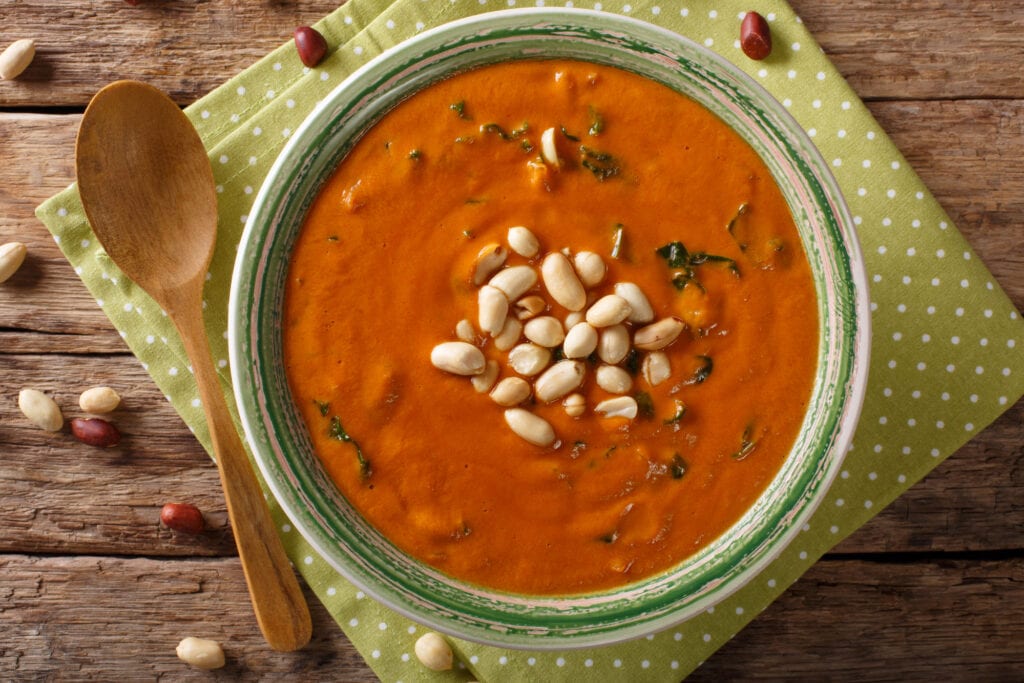 Vegetarian West African Peanut Soup close-up in a plate. on the table. horizontal top view from above