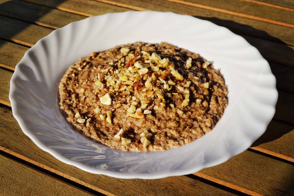 A bowl of oatmeal with nuts on top, a delicious and hearty breakfast option.