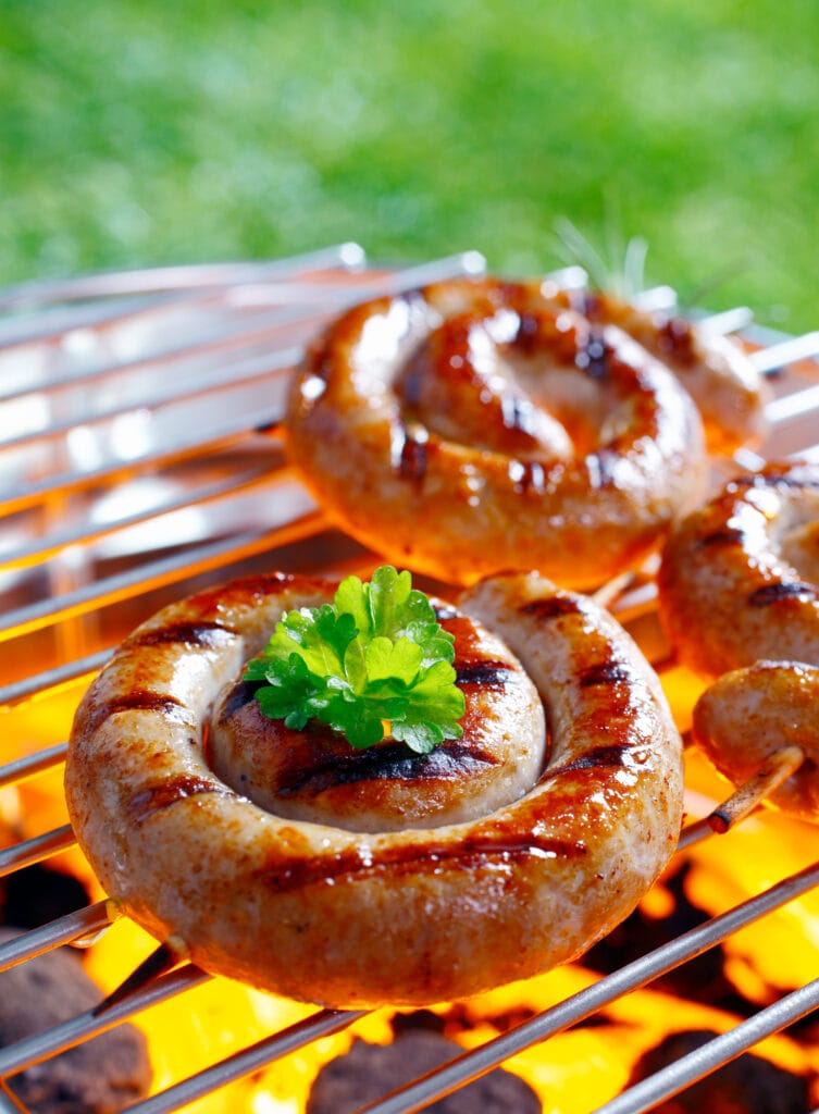 Smoking Rolled sausage on the grilling pan with open flames