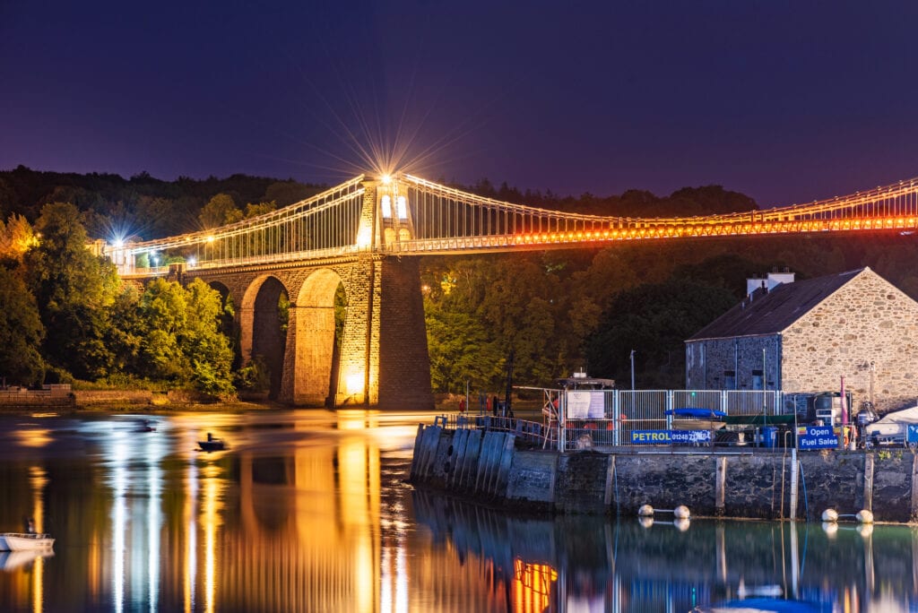 ANGLESEY, UNITED KINGDOM - SEPTEMBER 06: Night view of the famous Menai Suspension bridge alog the Menai Straits on September 06, 2018 in Anglesey