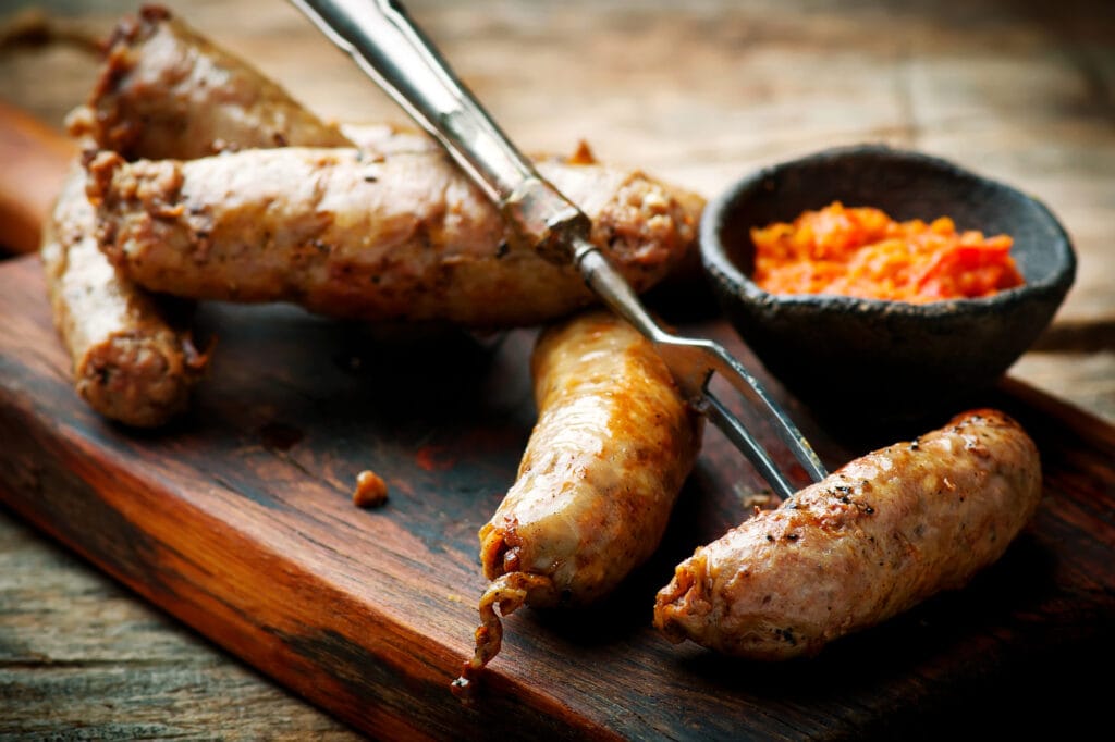 Merguez Sausages with harissa on wooden board.style rustic.selective focus