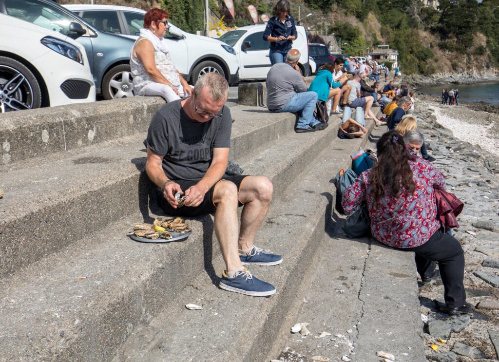 Cancale, France - September 15, 2018: People eating oysters bought on the seafront at Cancale, Brittany, France
