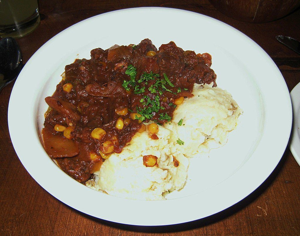 White plate of a dark brown burgoo stew from Kentucky