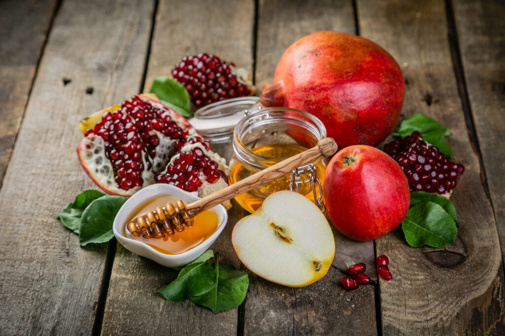 Honey and pomegranate on a wooden table.