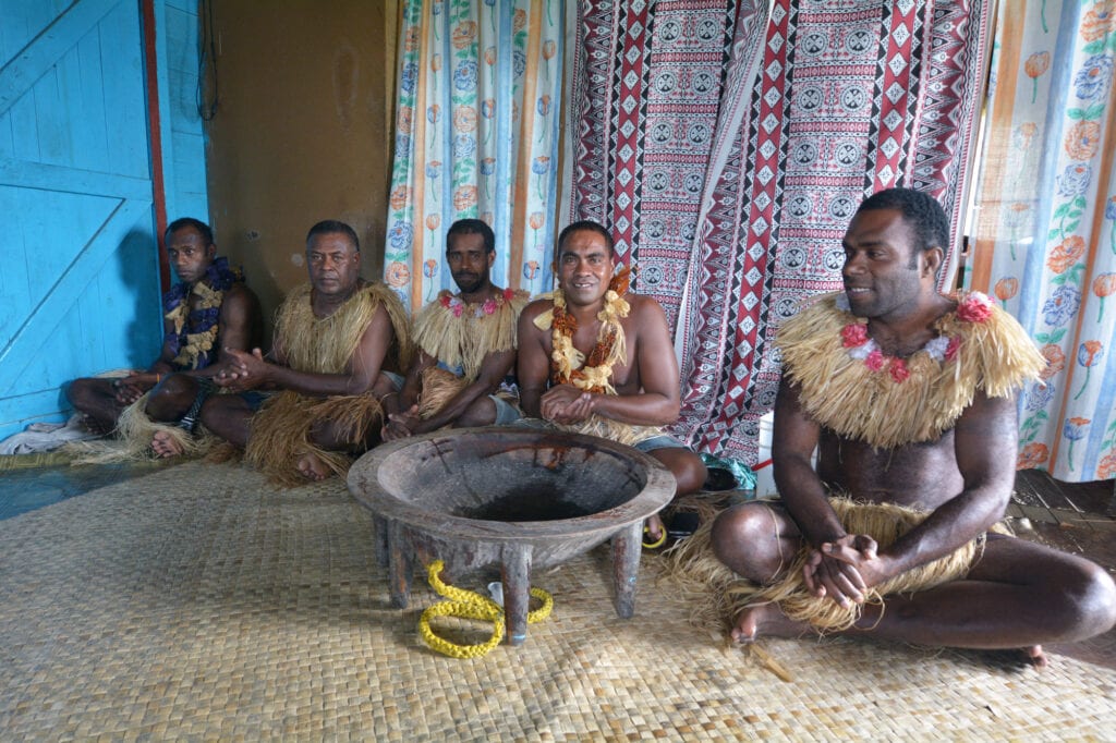 World of drinks, a kava ritual in Fiji. Several men sit around a kava bowl preparing the kave to be drunk for the ceremony