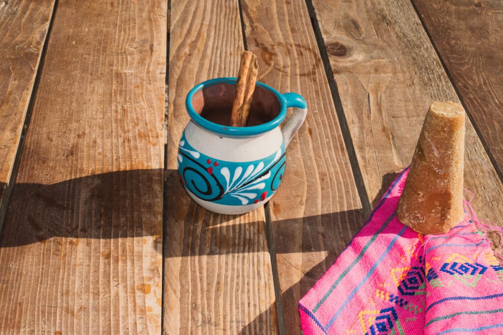 Mexican coffe ( café de la olla ) with cinnamon and brown sugar on a Mexican serape