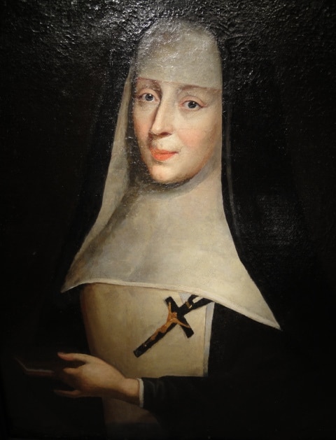 A painting of a nun holding a cross at Fontevraud Abbey.