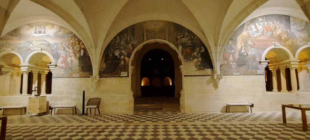 The interior of Fontevraud Abbey, with paintings on the walls.