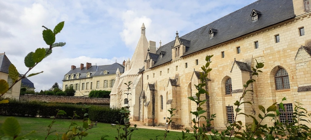 Fontevraud Abbey, a large stone building in the middle of a grassy field.
