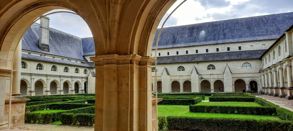 The courtyard of Fontevraud Royal Abbey, a large building with arches.