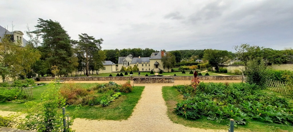 A view of Fontevraud Royal Abbey with a garden in the foreground.