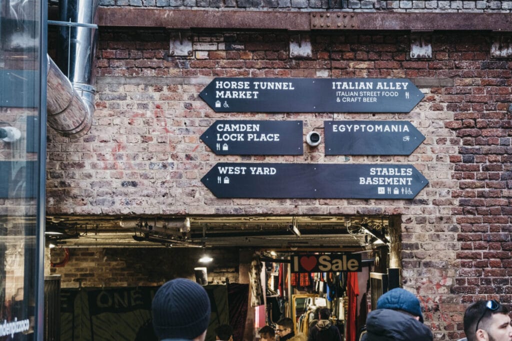 London, UK - November 26, 2019: Directional signs in Camden Market, a popular tourist attraction and the busiest retail spot in London, UK. Selective focus.