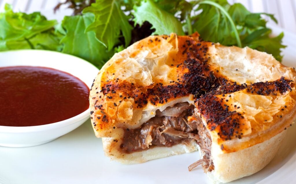 Gourmet beef pie, with salad and tomato sauce. An Australian hand pie