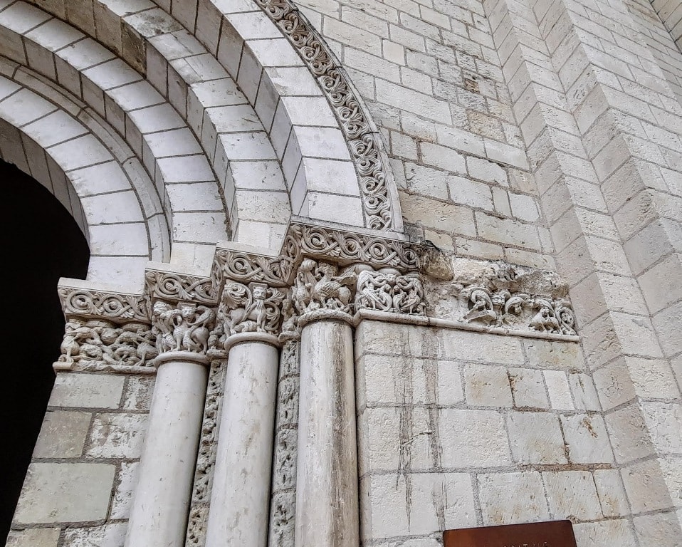 The arches of Fontevraud Abbey, adorned with a sign.