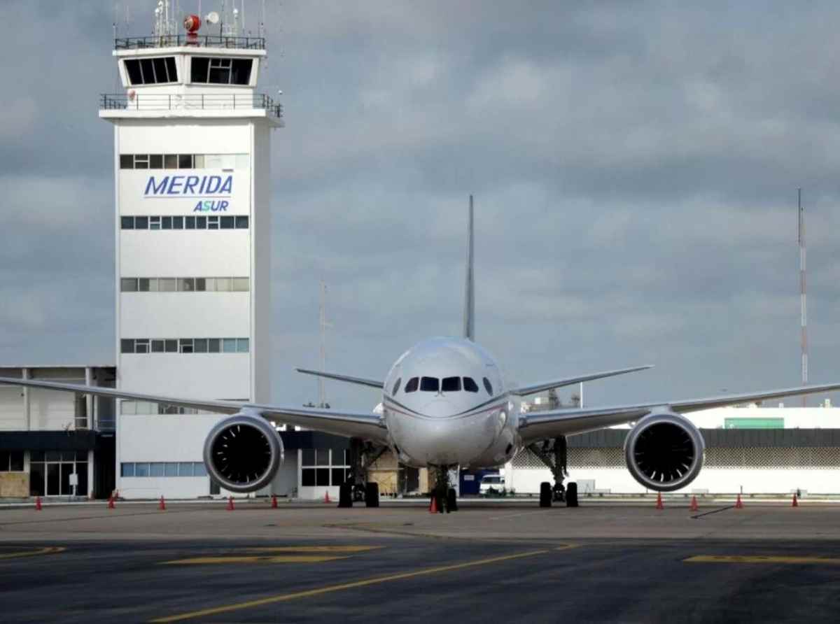 Merida airport with a plane on the runway in front of the tower