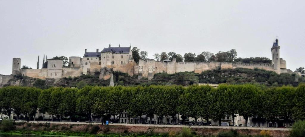 A view of the Chateau Chinon from the riverside showing the ancient fortress walls and remaining buildings