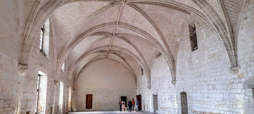The inside of the Fontevraud Royal Abbey, a stone building with arches.