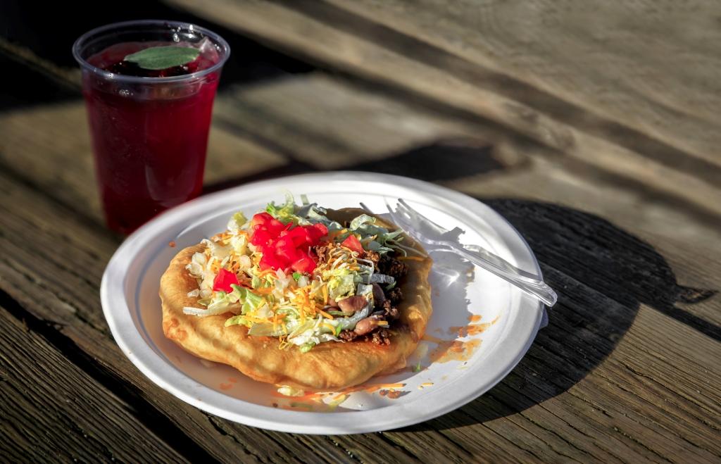 Traditional Native American herbal blackberry sage ice tea in a glass and an Indian Taco flatbread