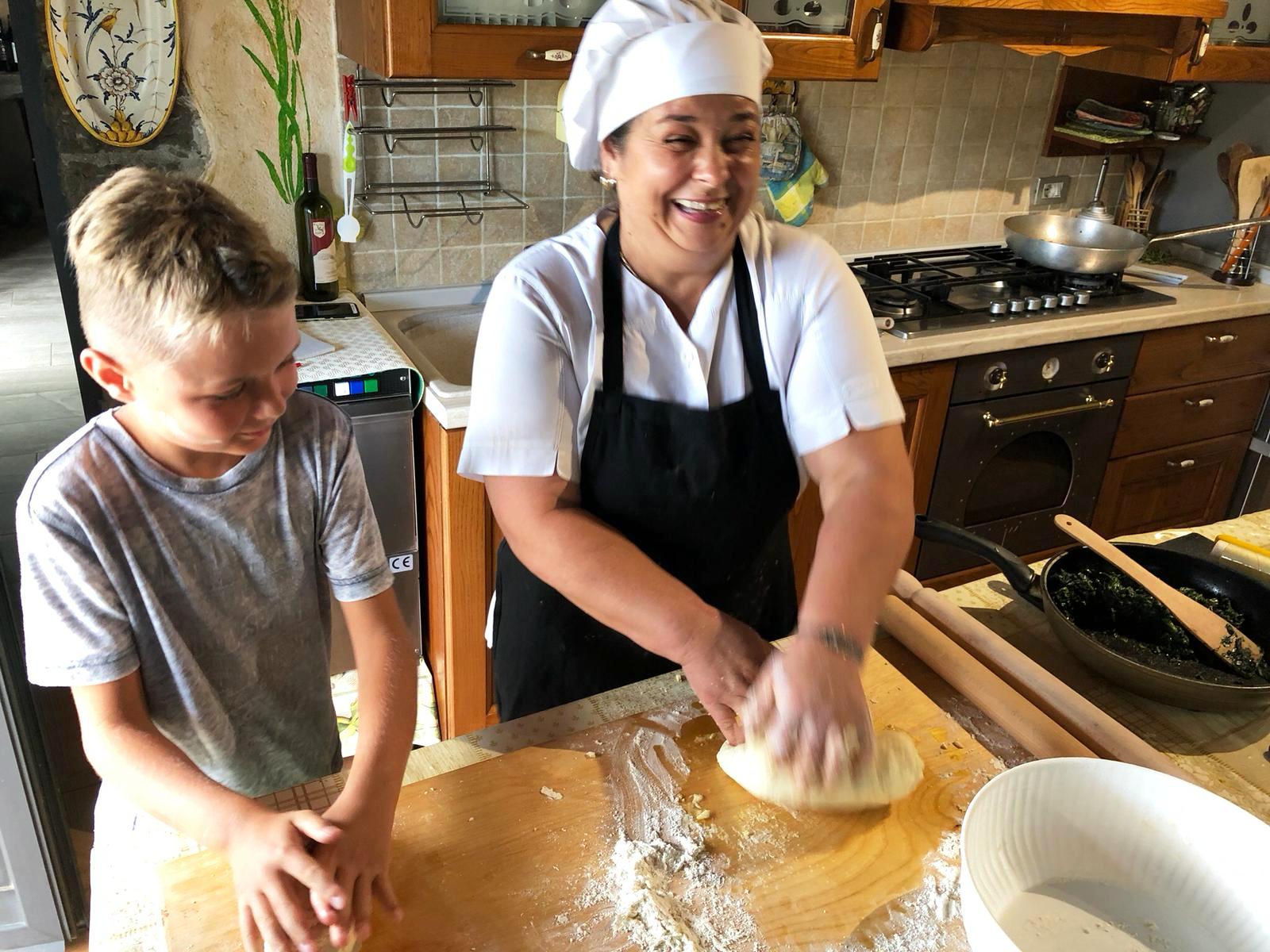 Liliana teaching a young boy how to make home made pasta - a cooking class in Tuscany