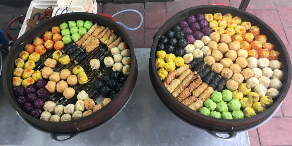 this tiny bite-sized Chinese dish comes in eye-catching colours at Fat Man Dim Sum stall at the Jalan Alor. Fat Man’s dim sum dumplings are not only a delight for the eyes but also a delight for the palate. The multi-coloured dim sum dumplings are prepared in steamers on the stall and filled with pork, chicken, crab, prawns, and cabbage.