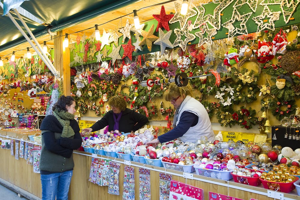 Barcelona Christmas market with a stall holder selling christmas decorations