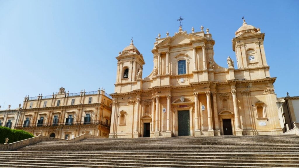 Noto, Sicily is a gorgeous historic town in southern Sicily that is definitely worth a visit. with one of its beautiful baroque buildings with columns and carvings in a pink stone