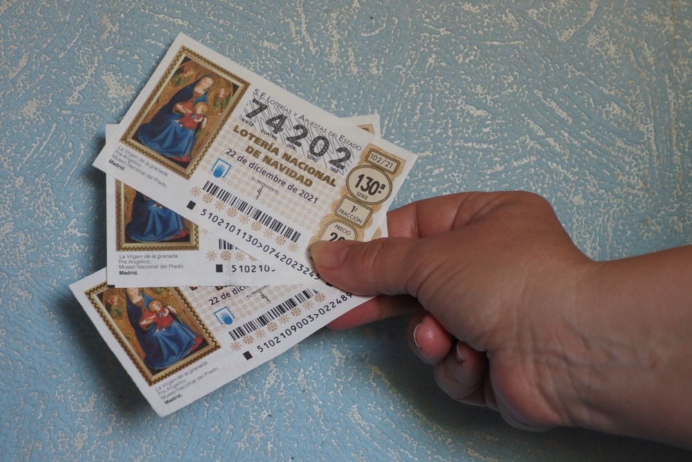 ALCALA DE HENARES, SPAIN - Aug 29, 2021: A closeup of a woman's hand as she holds 3 tickets of the Spanish Christmas lottery