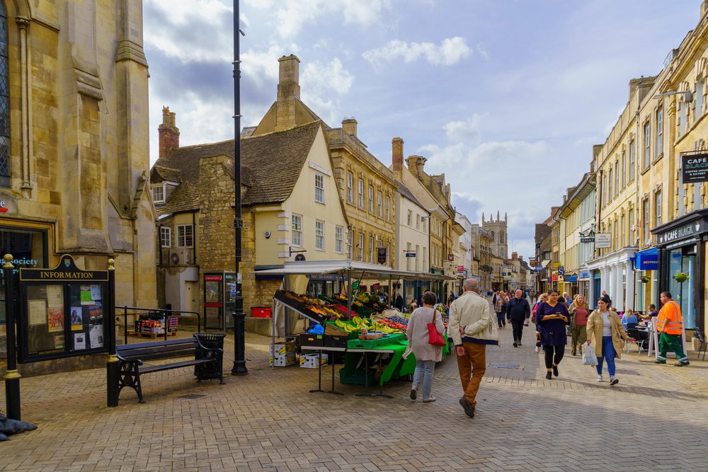 Stamford market in Stamford Lincolnshire a cobbled road set with market stalls and shopps