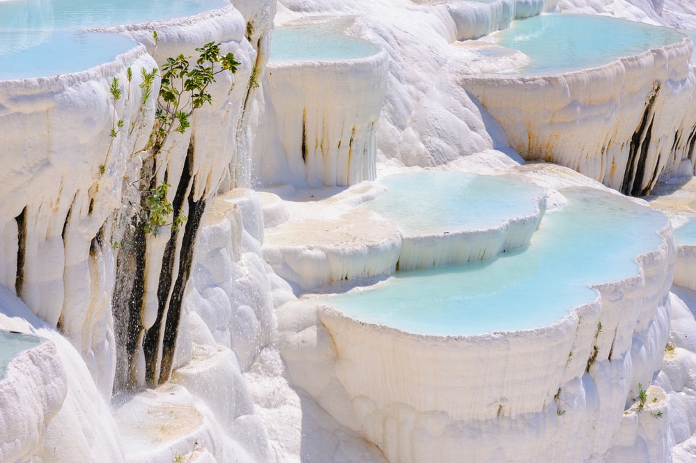 Blue cyan water travertine pools at ancient Hierapolis, now Pamukkale, Turkey - hot springs in Turkey