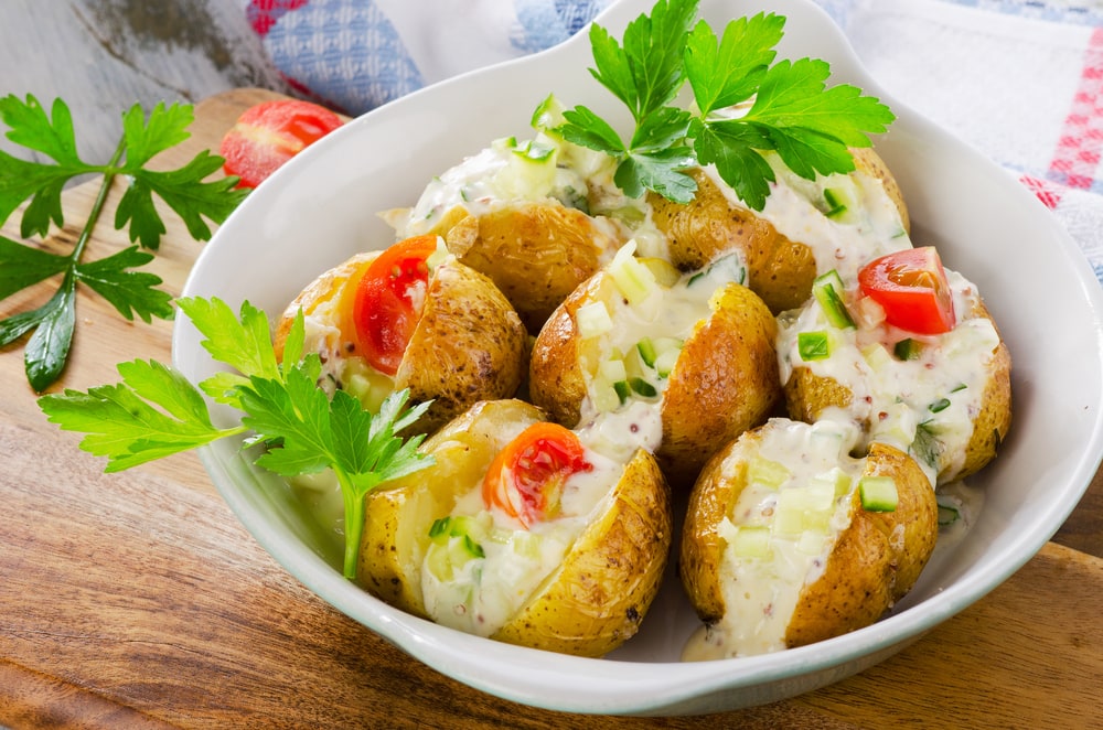Hot baked potatoes with vegetables and sour cream.