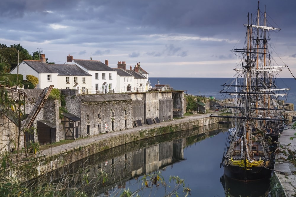 Tall ships docked in historic Charlestown Harbour on the coast of Cornwall, England