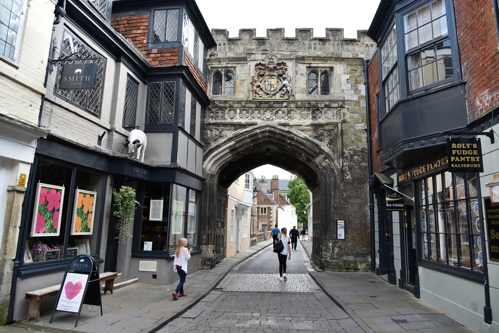 The gates into Salisbury England, these are Victorian with a printed arch and the stones are grey with a coat of arms above the arch. 