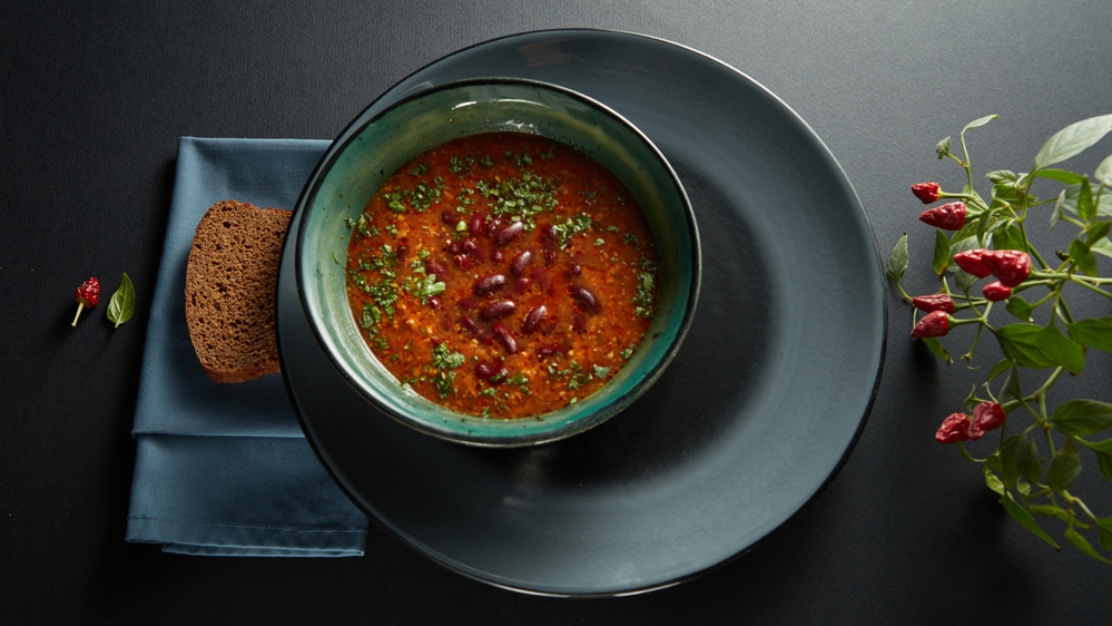 A bowl of Armenian soup and bread on a table.