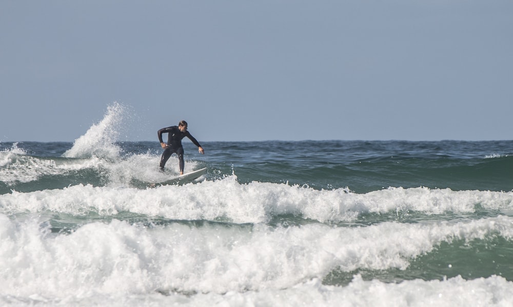 Surfer riding crest of a wave at Fistral Beach Newquay Cornwall
