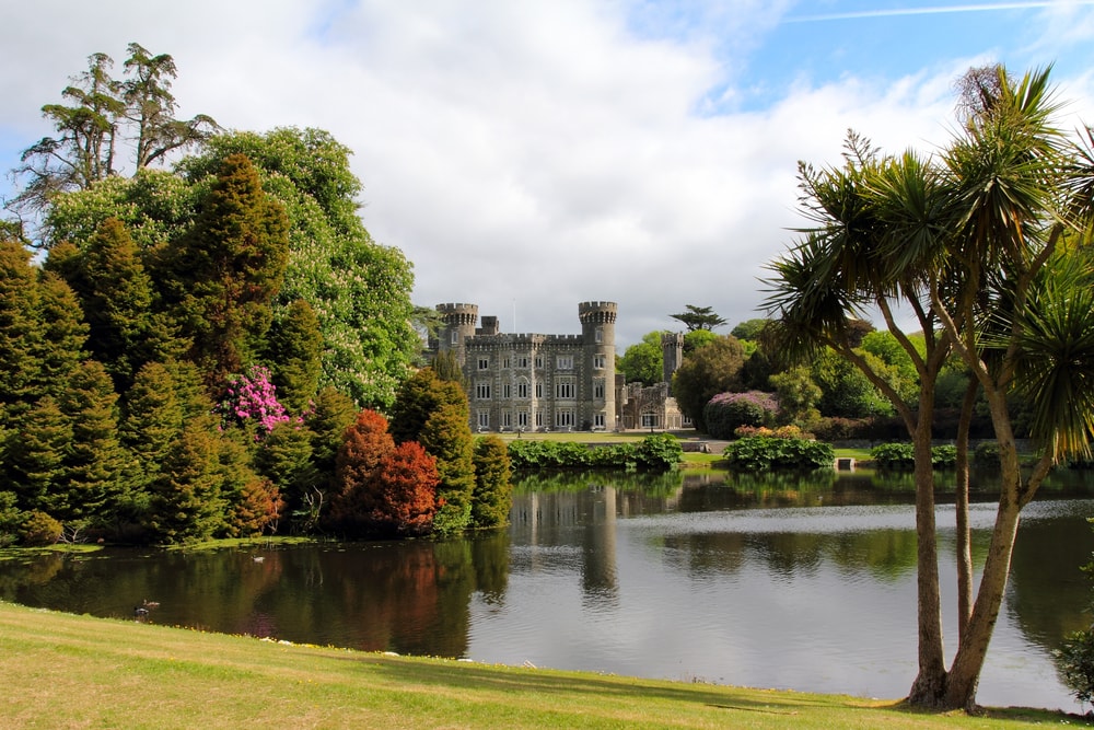 Irish castle of Johnstown taken from the beautiful gardens and pond . Wexford county Ireland