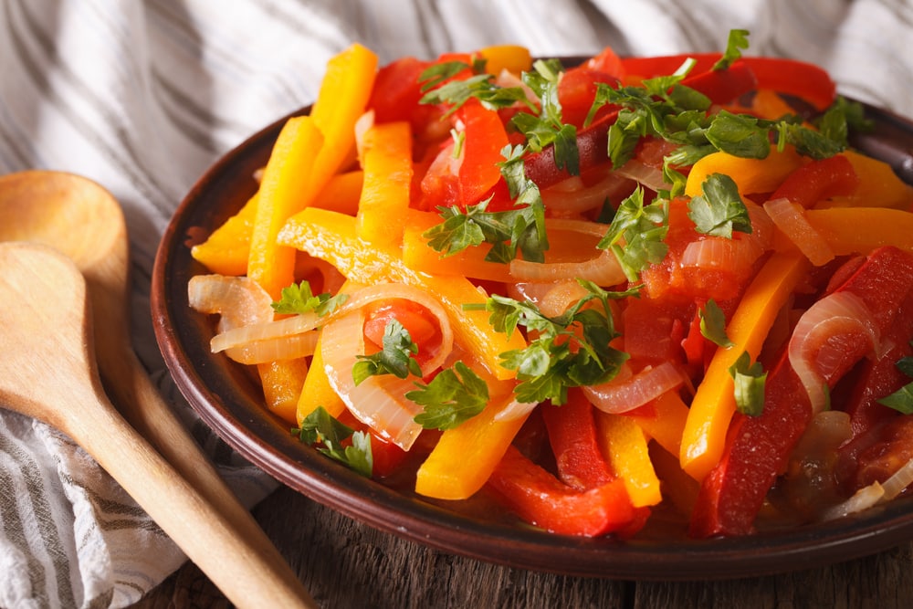 Piperade Appetizer: stewed peppers with tomatoes and onions close up on a plate.