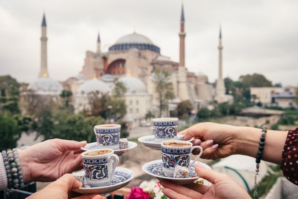 Woman travel in Istanbul and and drink turkey coffee in cafe near Hagia Sophia famous islamic Landmark mosque, Travel to Istanbul, Turkey background
