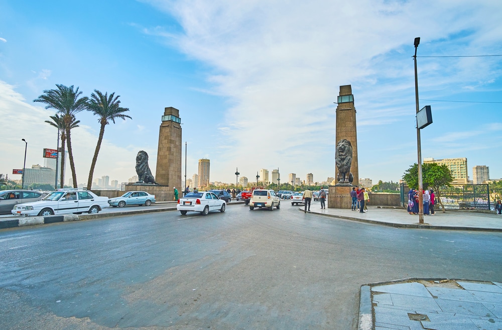 The busy El Tahrir road, decorated with stone towers and sculprtures of lions at the entrance of Qasr El Nil bridge, - things to do in Cairo