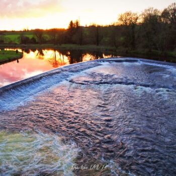 A glowing sunset reflection in the weir on the River Boyne at Ardmulchan, County Meath, Ireland