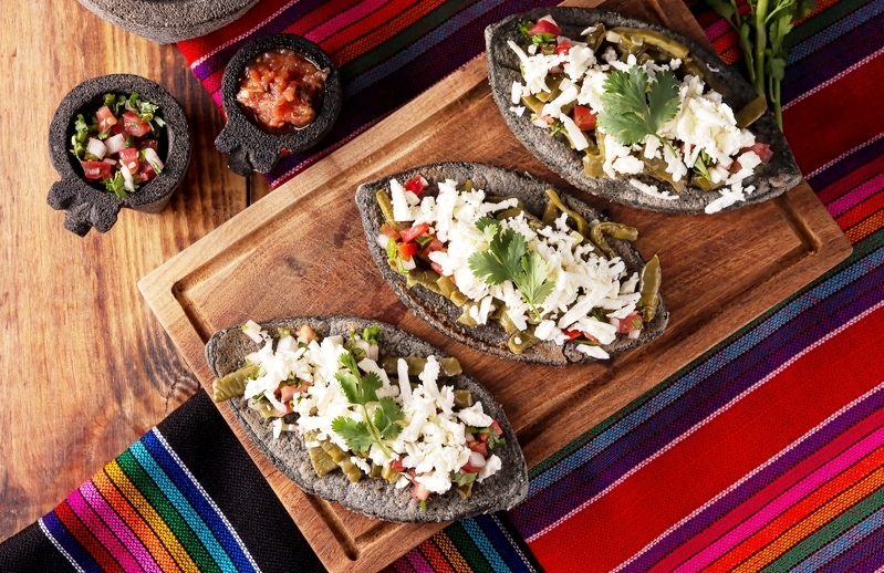 Tlacoyos. Mexican pre hispanic dish made of blue corn flour patty filled with refried beans. Popular street food in Mexico. 