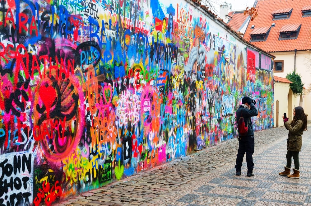 Tourists are at famous wall of John Lennon in Prague, Czech Republic